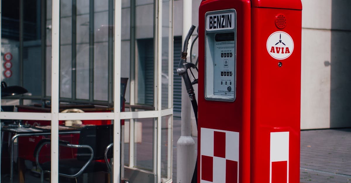 Red vintage gas pump outside with modern architecture backdrop in Frankfurt.