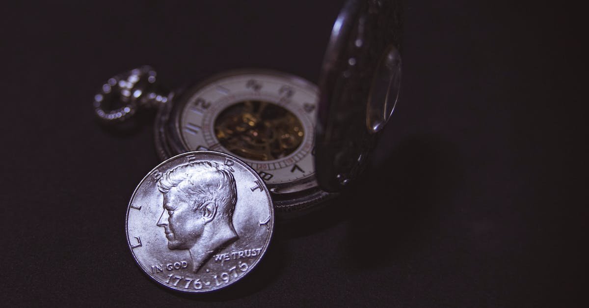 Close-up of a vintage silver coin with a pocket watch, symbolizing time and wealth.