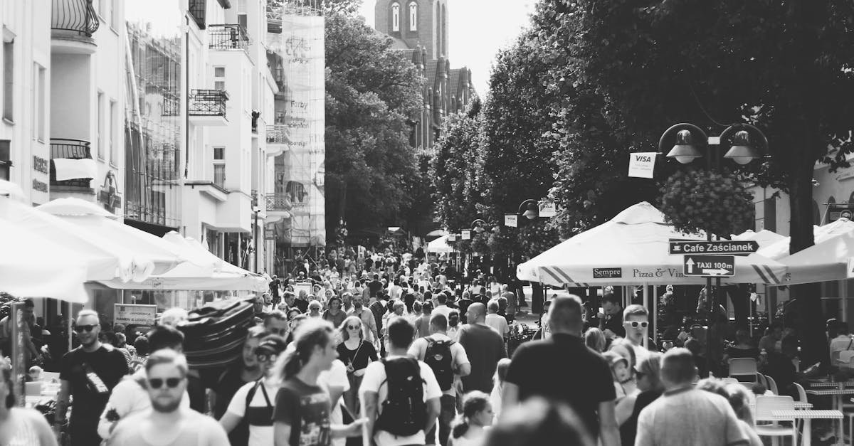 A black and white photo capturing a busy street filled with people in Sopot, Poland during the day.
