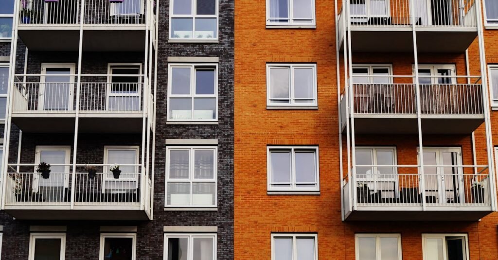Detailed view of a modern apartment building's exterior with balconies and glass windows.