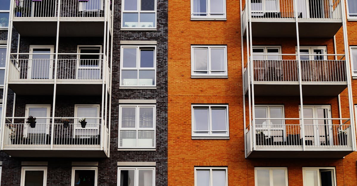 Detailed view of a modern apartment building's exterior with balconies and glass windows.