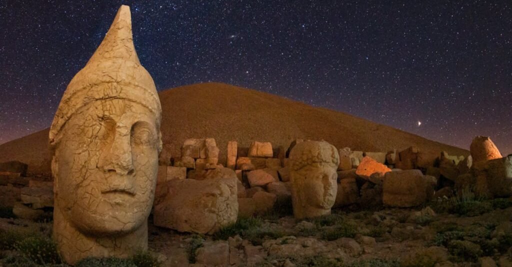 Captivating view of ancient statues on Mount Nemrut under a starry night in Adıyaman, Turkey.