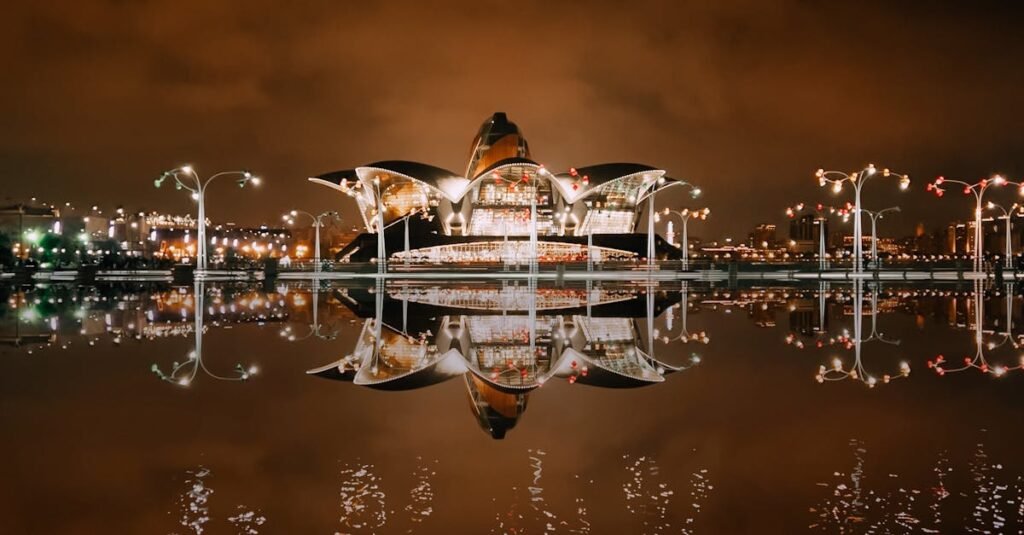 Illuminated Deniz Mall reflected in water against a night sky, Baku, Azerbaijan.