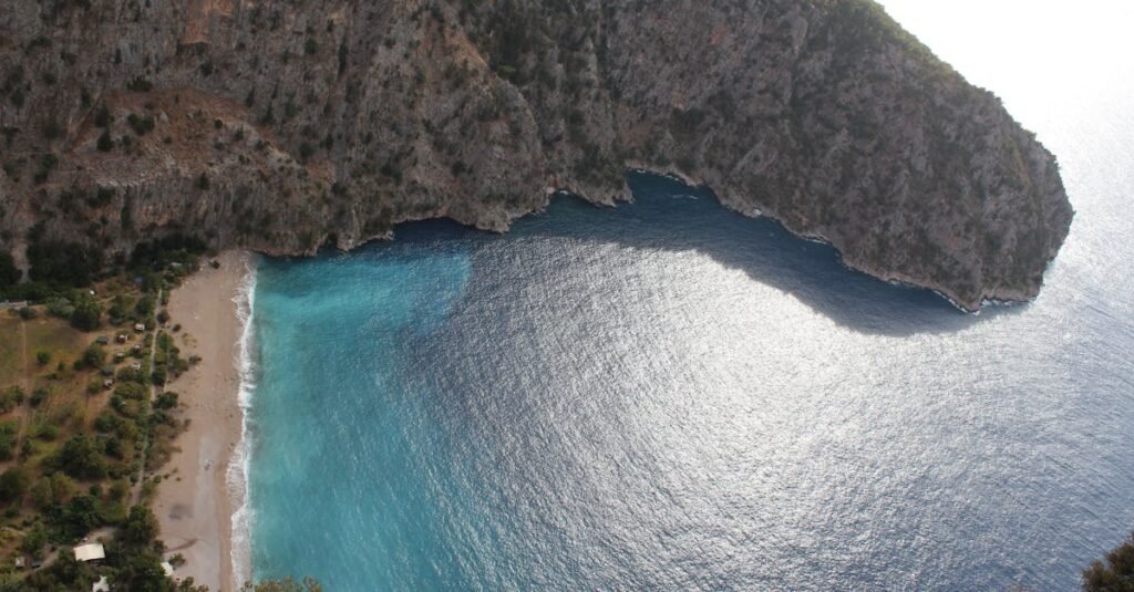 Scenic aerial view of Butterfly Valley's turquoise waters and rugged cliffside in Fethiye, Turkey.