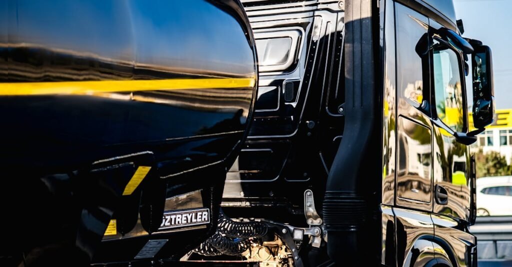 Black semi truck ready for cargo loading at an industrial dock.