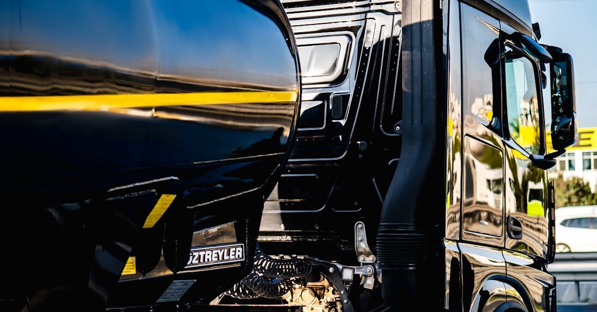 Black semi truck ready for cargo loading at an industrial dock.