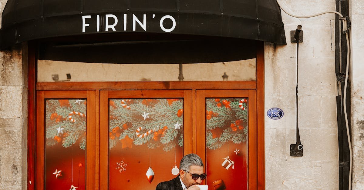 A man in a suit enjoys coffee at an outdoor café with elegant doorway and patio seating.