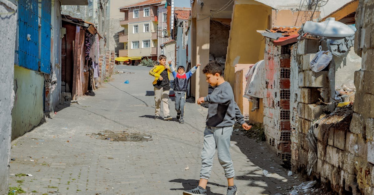 Children playing on a sunlit street in Tekirdağ city, Türkiye, showcasing urban life.