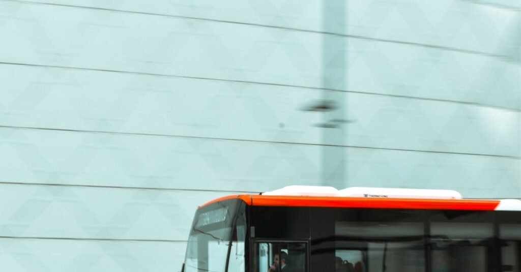 Dynamic cityscape with a red bus in motion, set against a modern building facade.