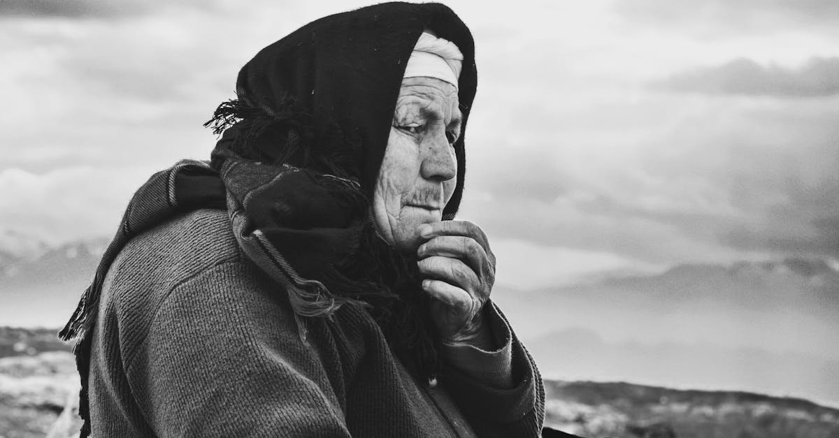 Black and white portrait of an elderly woman with mountains in the background, Salihli, Türkiye.