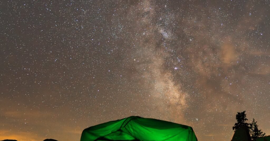 A glowing tent under the starry sky and Milky Way at a campsite in Innsbruck, Austria.