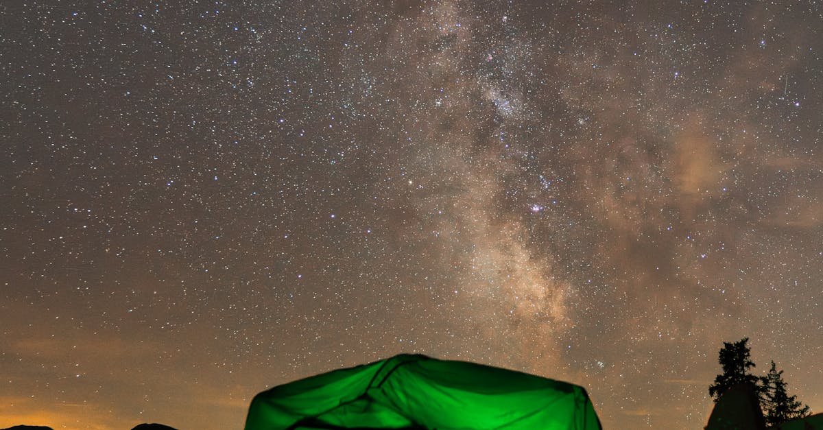 A glowing tent under the starry sky and Milky Way at a campsite in Innsbruck, Austria.