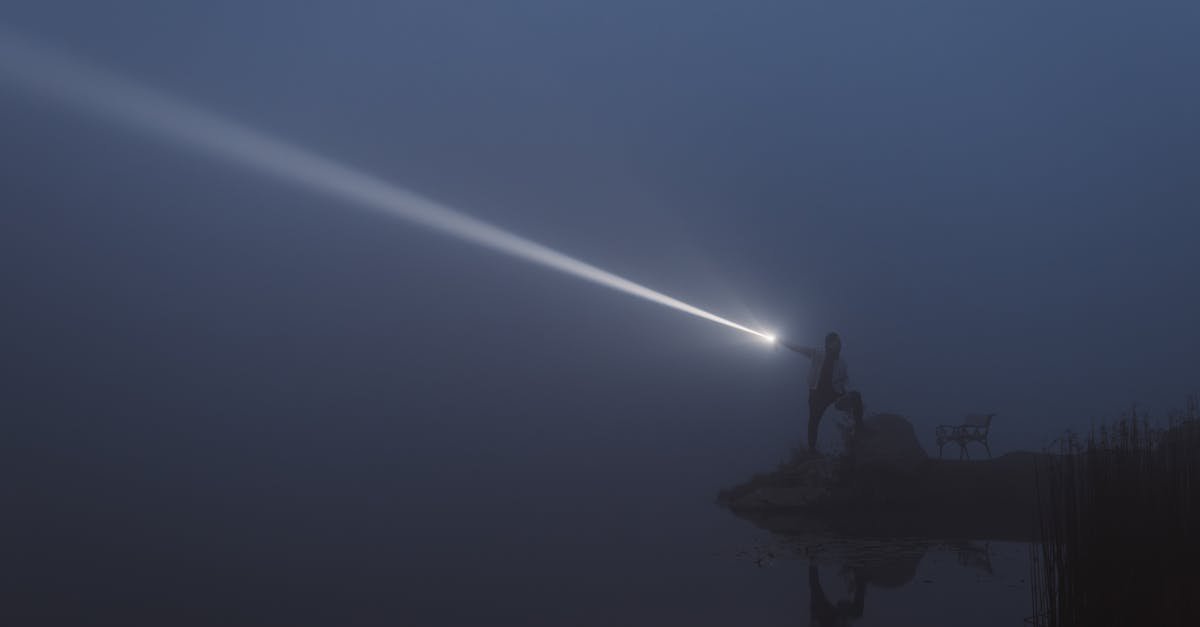 A serene lakeside exploration at night with flashlight illuminating the mist in Styria, Austria.