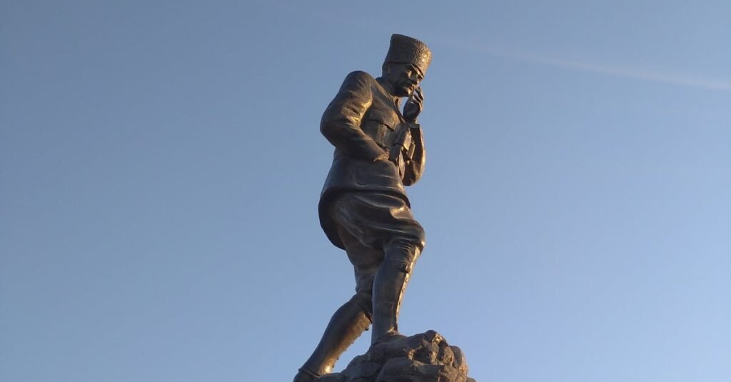 Majestic statue of Atatürk against a clear blue sky in Bandırma, Turkey.