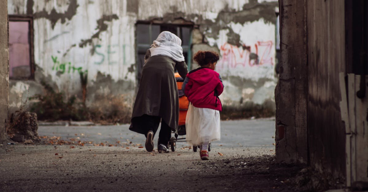 A mother and child in vibrant clothing walk through old streets in Erzurum, Türkiye.