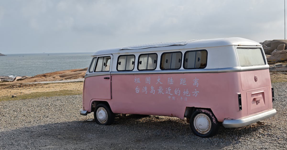 A retro pink van parked by the sea in Kinmen, Taiwan, with ocean views.