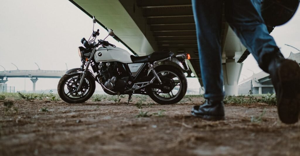 Motorcycle parked under a bridge with a person walking by, creating a dynamic urban scene.