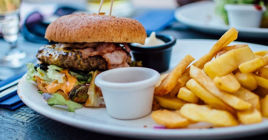 Close-up of a juicy burger and crispy fries served with sauces, perfect for a hearty meal.