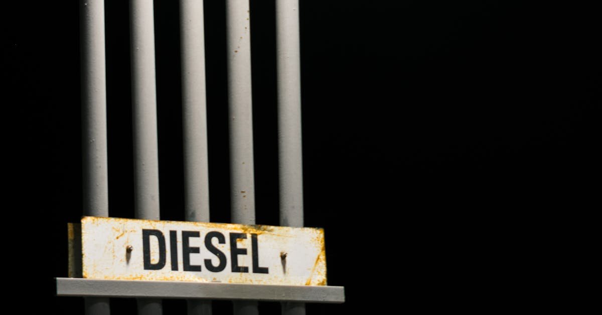 Diesel fuel sign on metal pipes against a dark black background at night.