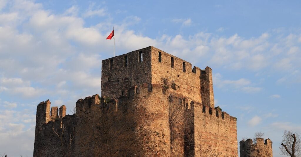 Historic Rumeli Fortress with Turkish flag in İstanbul, Türkiye under a clear blue sky.