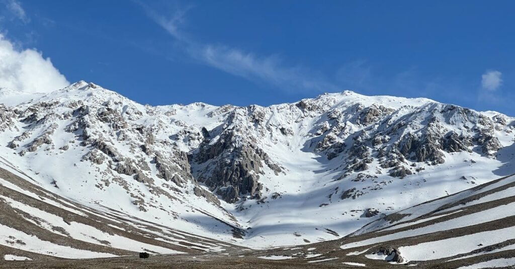 Breathtaking view of snow-covered mountains under a clear blue sky.