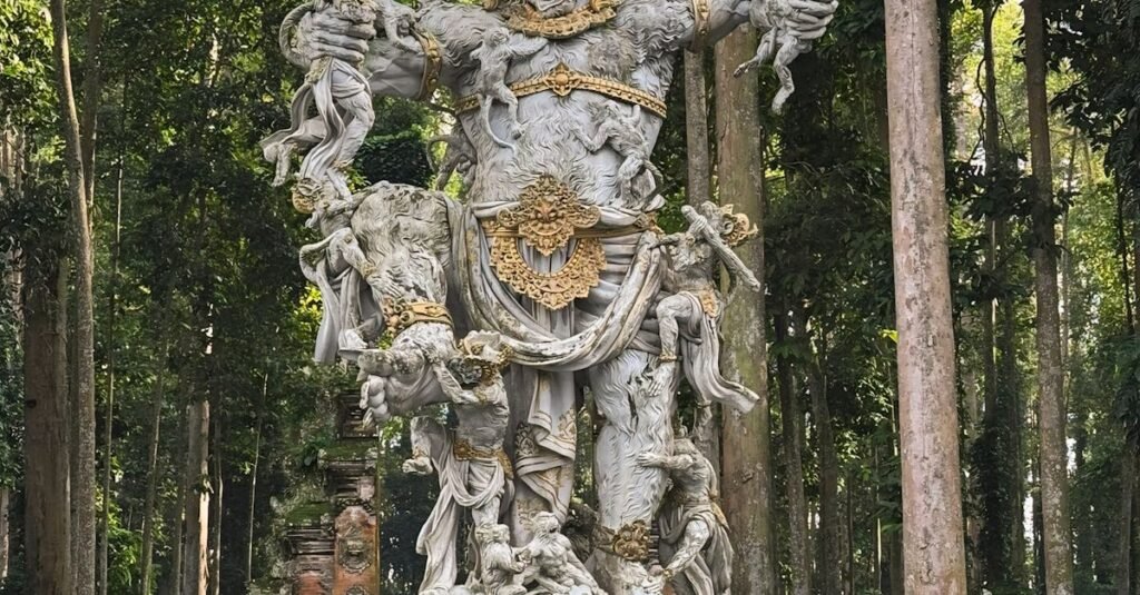 A detailed stone sculpture with golden accents in a Balinese forest setting.