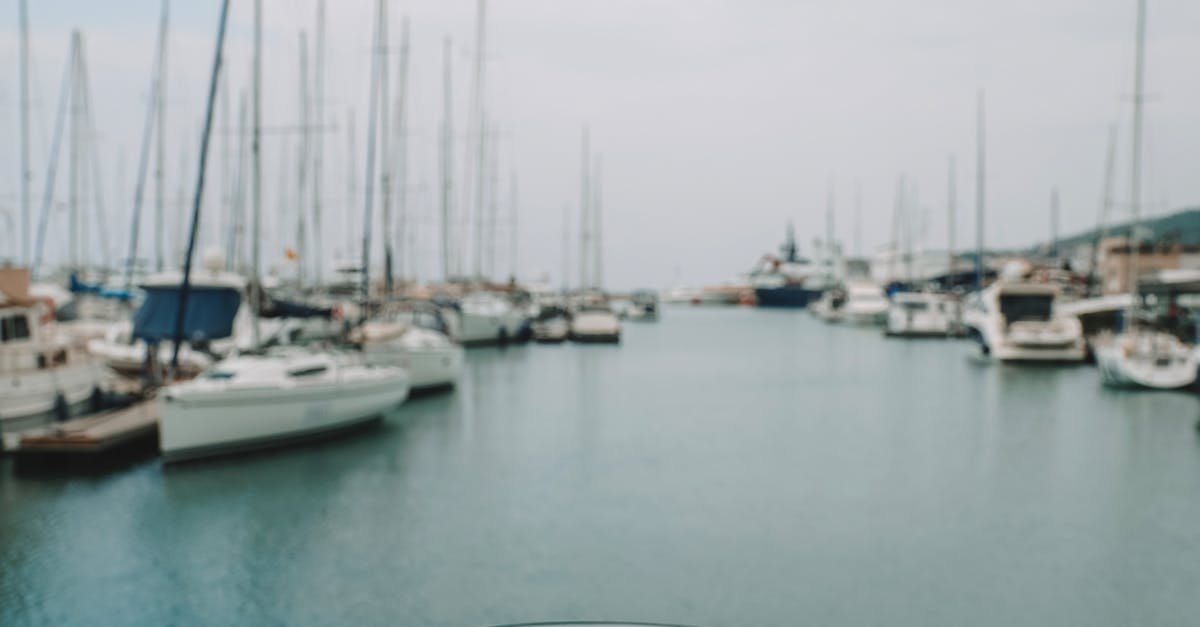 A hand holding coffee with Çeşme Marina's yachts in the background.