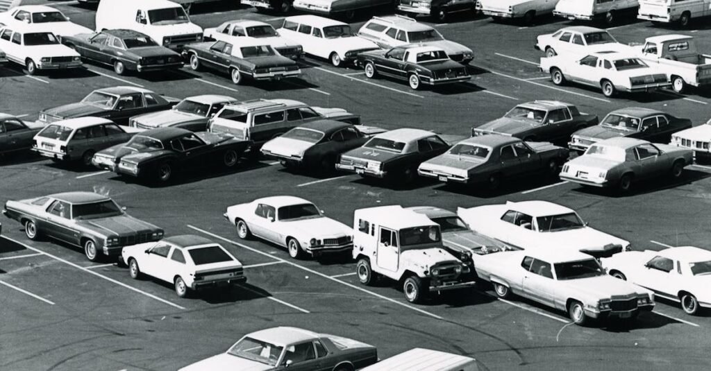 Aerial view of a parking lot filled with vintage cars in a classic black and white setting.