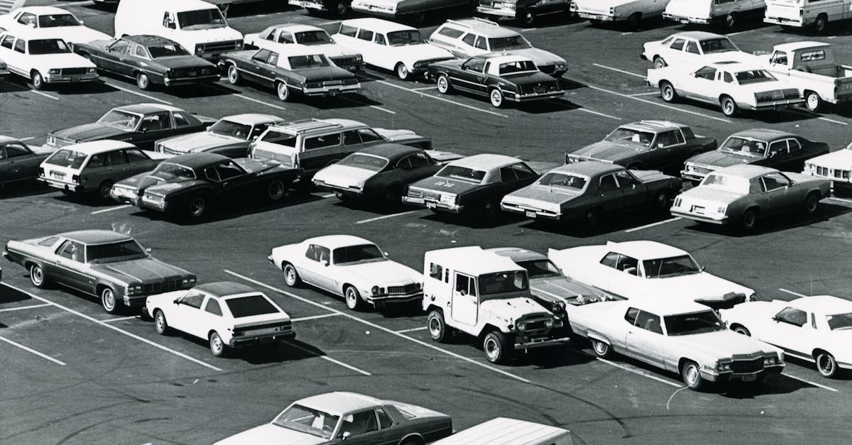Aerial view of a parking lot filled with vintage cars in a classic black and white setting.
