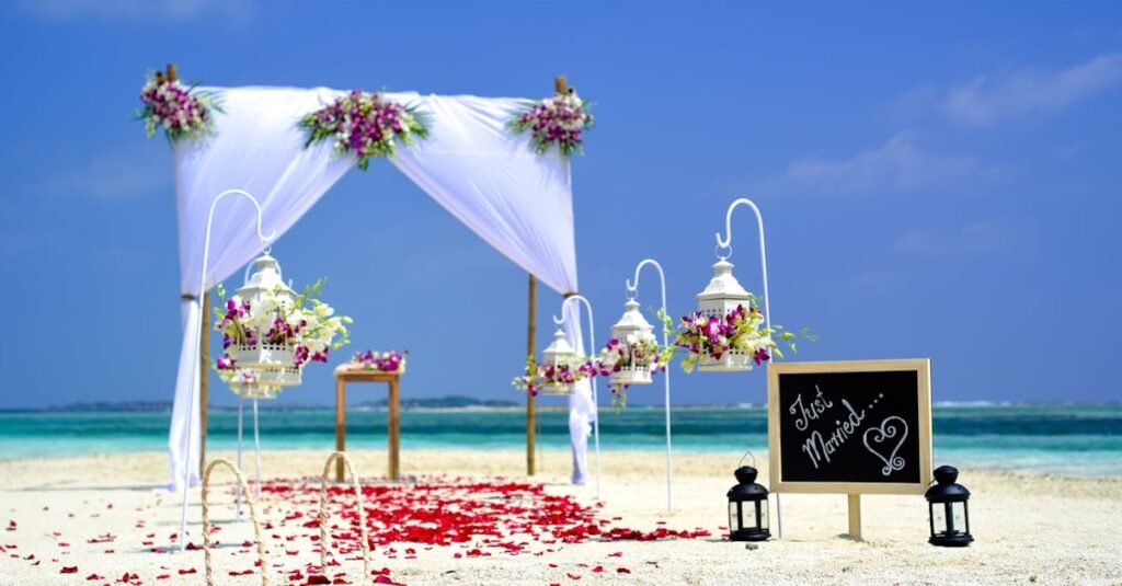 Stunning beach wedding arrangement with floral decor and lanterns on a sunny day.