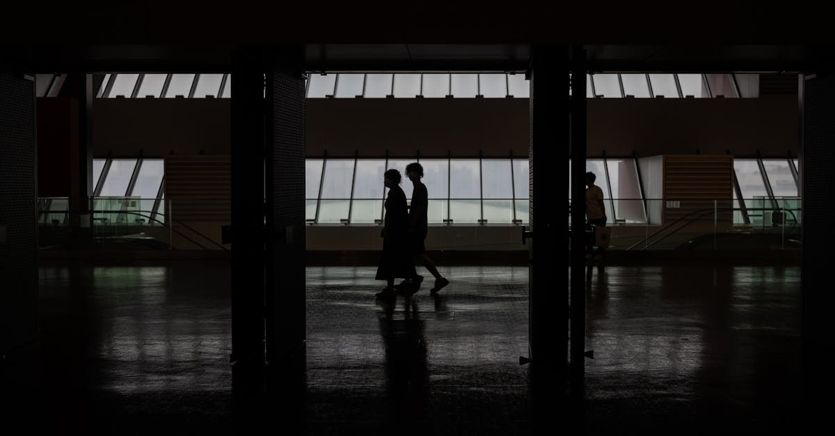Silhouette of people walking through a modern hallway with large windows in Shanghai, China.