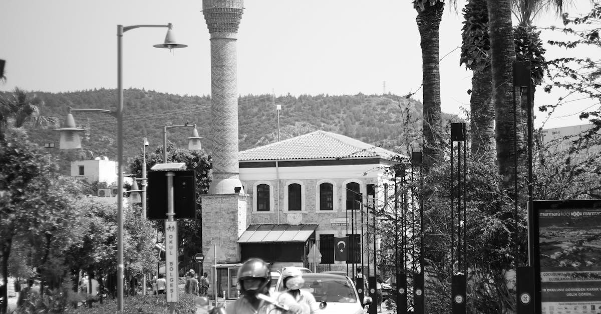 Black and white photo of a busy street in Bodrum featuring a mosque and palm trees.