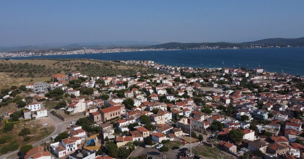 Aerial shot of Ayvalık's charming houses and coastline under a clear blue sky in summer.