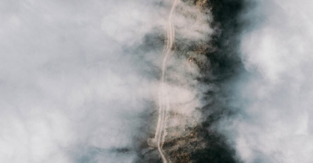 A mysterious aerial photograph capturing a winding road through dense fog in Artvin, Türkiye.