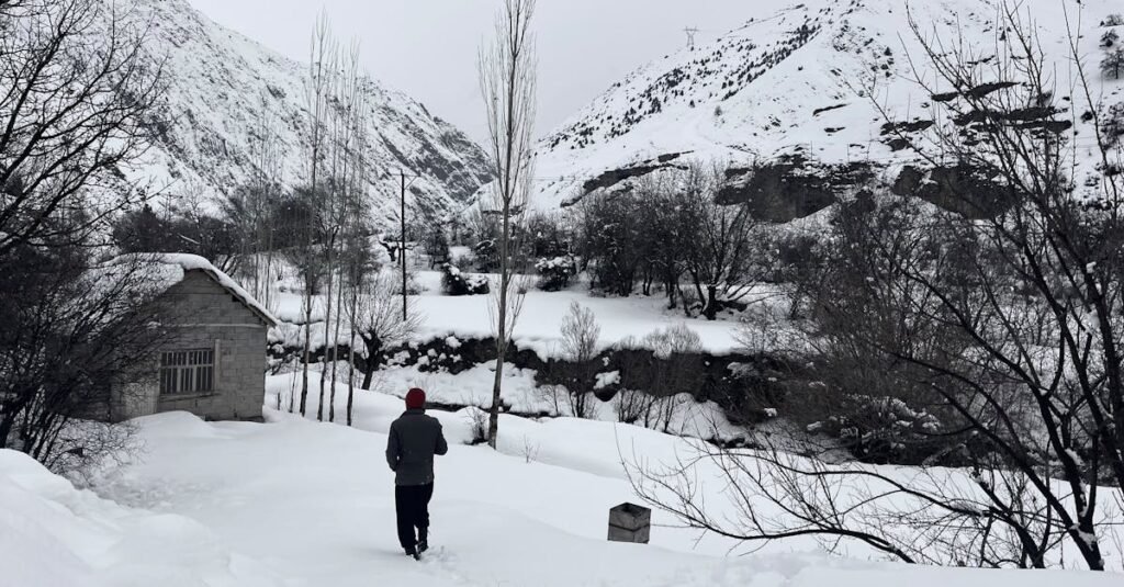Snowy mountain landscape with a figure and a hut in Hakkâri, Türkiye.