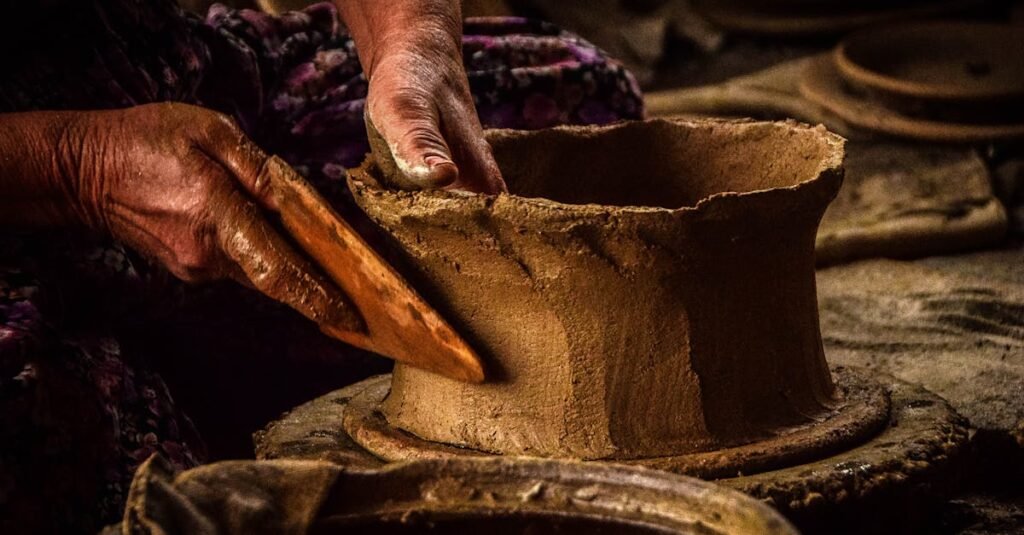 Detailed view of hands shaping pottery clay, highlighting traditional craftsmanship skills.
