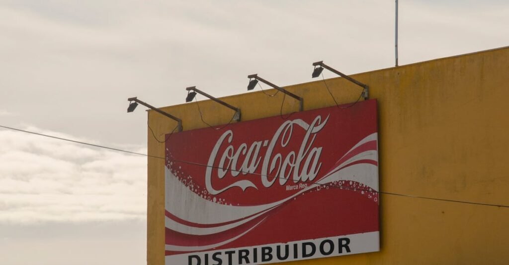 Outdoor view of Coca-Cola distributor sign on a building under a clear sky.
