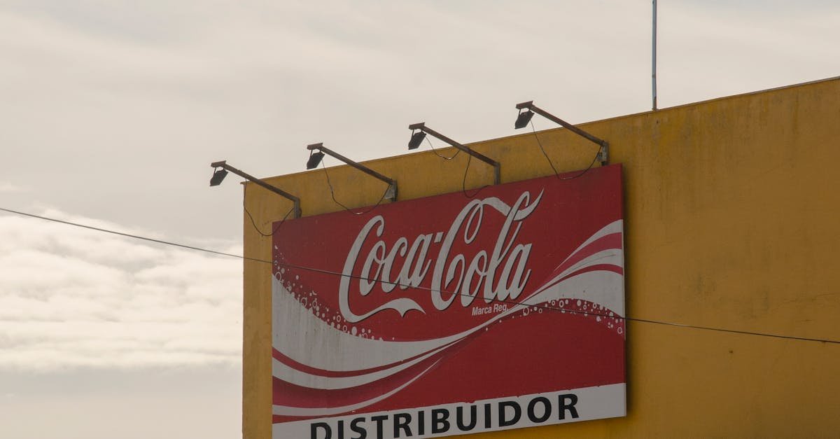 Outdoor view of Coca-Cola distributor sign on a building under a clear sky.
