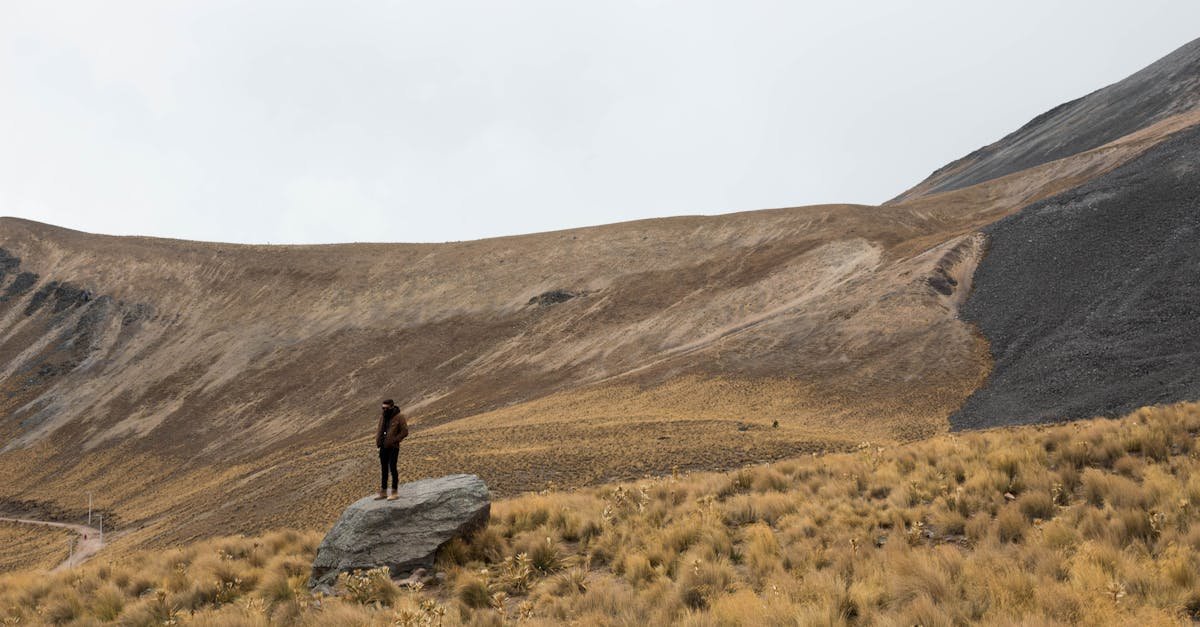 Lone hiker on a rocky landscape in Toluca, Mexico, surrounded by dry hills.