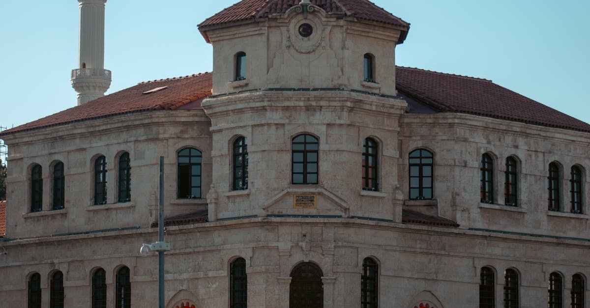 Historic Ottoman-style building with minaret under clear sky, featuring traditional architecture.