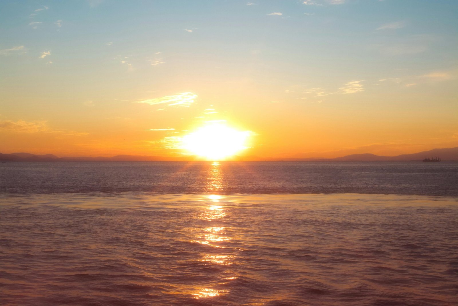 Tranquil sunset over the sea in İzmir, Türkiye, highlighting warm colors and a peaceful horizon.