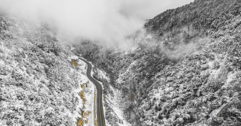 Aerial view of a winding road cutting through snow-covered mountains in Domaniç, Kütahya, Türkiye.