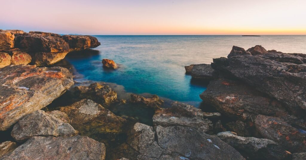 A tranquil sunset view over the rocky Mediterranean coast in Illes Balears, Spain.
