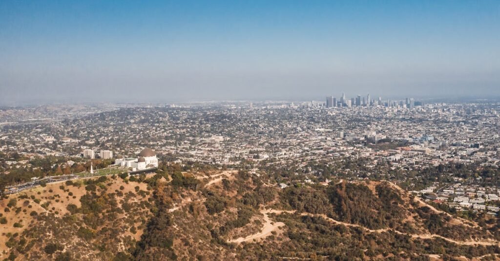 Stunning aerial view of Los Angeles with Griffith Observatory in the foreground on a clear day.