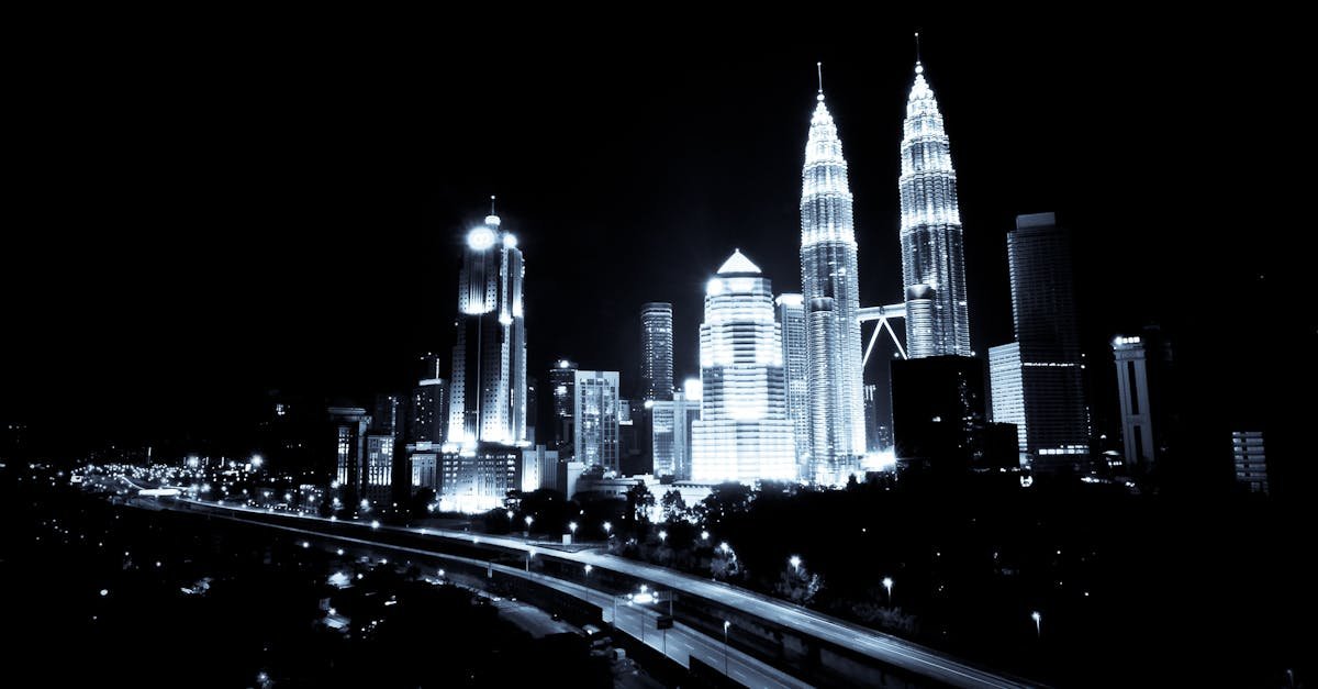 A breathtaking black and white view of Kuala Lumpur skyline featuring illuminated skyscrapers at night.