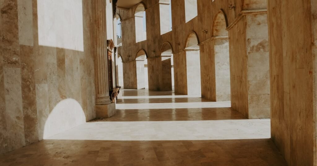 Sunlit stone corridor with archways creates an ancient and historic ambiance.