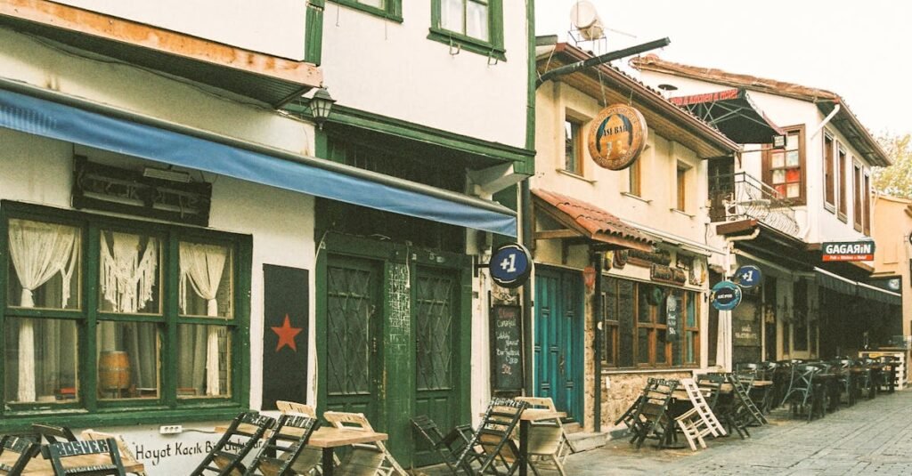 Vintage European street view with charming storefronts and outdoor cafes, offering an inviting ambiance.