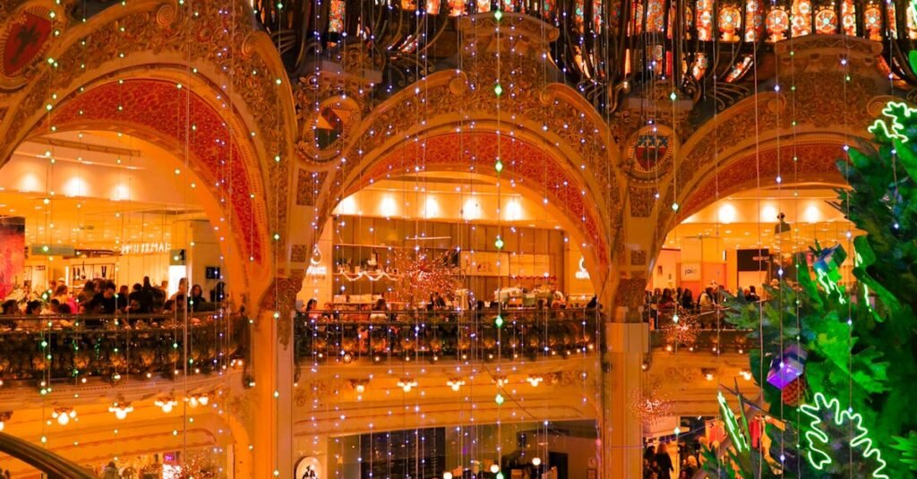 Illuminated view of a decorated Paris shopping mall interior during the holiday season.