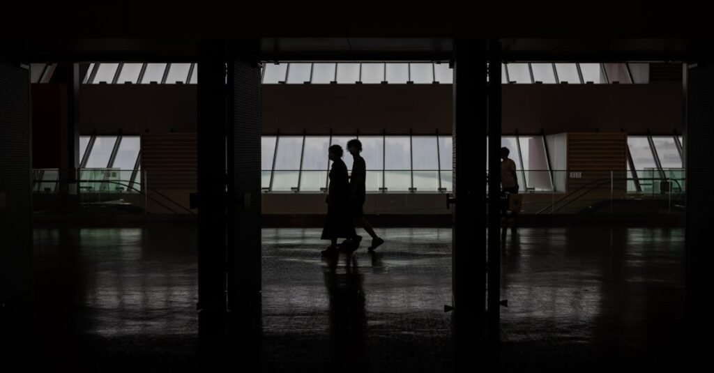 Silhouette of people walking through a modern hallway with large windows in Shanghai, China.