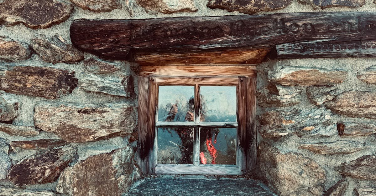 A vintage wooden-framed window on a rustic stone wall, showcasing architectural charm.